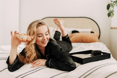 Young woman lying down on bed at home