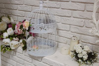 Close-up of decorative cage with roses on ledge