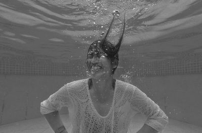 Young woman in swimming underwater in pool