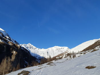 Scenic view of snowcapped mountains against clear blue sky