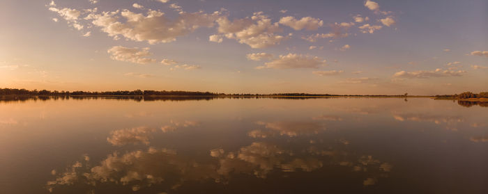 Drone panorama of a mirror lake in the outback during sunset with dramatic cloud formation