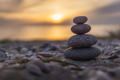 Stack of stones on beach during sunset