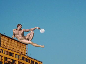 Low angle view of shirtless man against clear sky