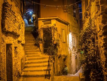 Illuminated steps amidst buildings in city at night