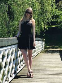 Portrait of woman standing on footbridge