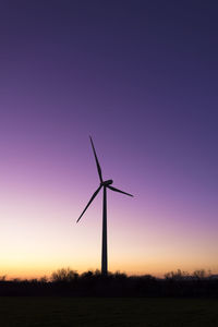 Wind wheel in a meadow at sunset