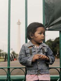 Portrait of a small child in front of the fence of the national monument