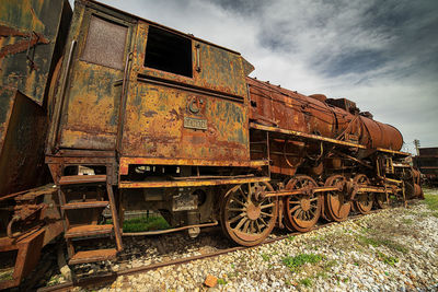 Abandoned train on railroad track against sky