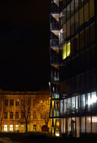 Low angle view of illuminated buildings against sky at night