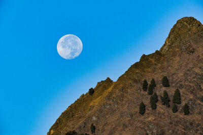 Low angle view of moon against blue sky