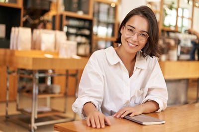 Portrait of young businesswoman working at table