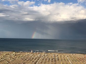Scenic view of sea against rainbow in sky