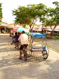 People on street against road in city