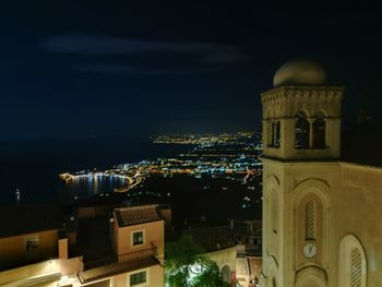 Illuminated buildings against sky at night