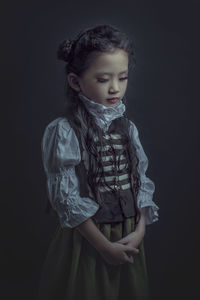 Cute girl standing against black background