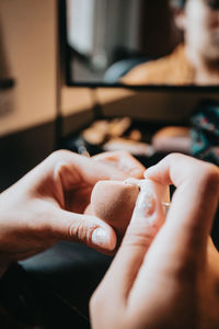 Hands of woman pouring foundation on blender