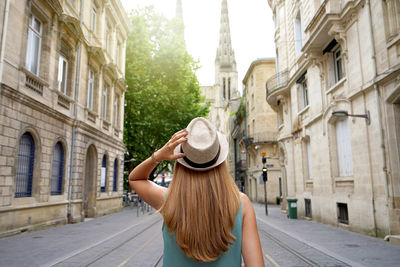 Tourist goes along rue vital charles towards the cathedral in bordeaux, france.