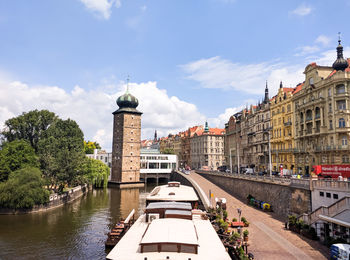 Buildings in city against cloudy sky