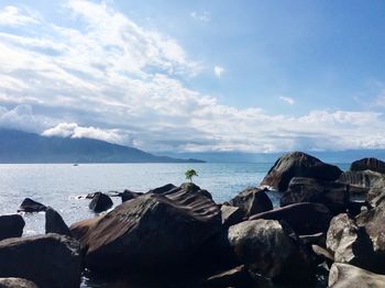 Panoramic view of rocks on beach against sky