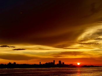 Scenic view of silhouette buildings against sky during sunset