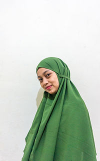 Portrait of smiling young woman against white background