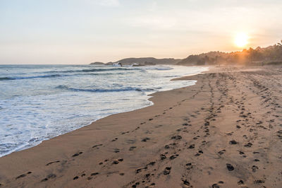 Scenic view of beach against sky during sunset