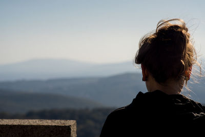 Rear view of woman looking at mountain against sky