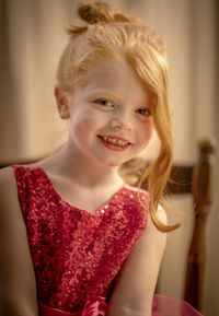 Portrait of girl smiling while sitting at home