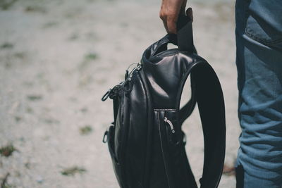 Cropped image of man holding backpack