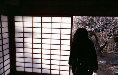 Silhouette of man against window