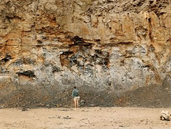 Rear view of a man walking on rock