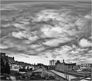 View of cityscape against cloudy sky