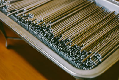 High angle view of steel chopsticks in container on table