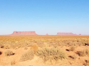 Scenic view of desert against clear blue sky