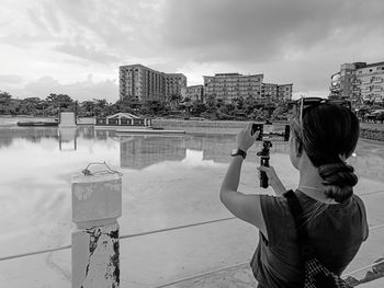 Man photographing against sky