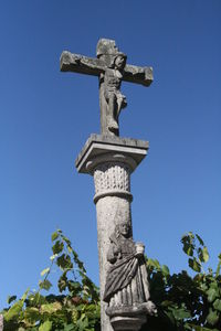 Low angle view of statue against blue sky