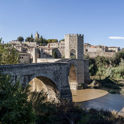 Arch bridge over river against buildings