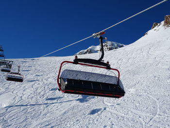 Overhead cable car on snowcapped mountains against clear blue sky