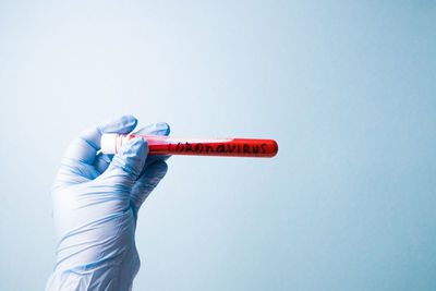 Close-up of hand holding umbrella against white background