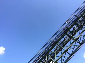 Low angle view of suspension bridge against clear blue sky