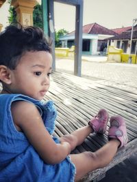 Portrait of cute girl sitting outdoors