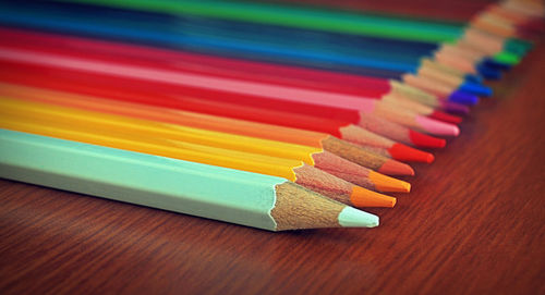 Close-up of colored pencils on wooden table