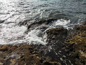 High angle view of waves splashing on rocks