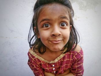 Close-up portrait of girl against wall