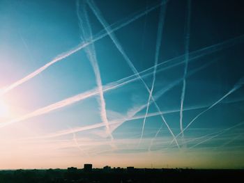 Low angle view of vapor trails against clear blue sky