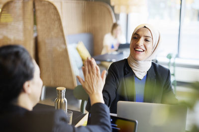 Woman in headscarf sitting in cafe