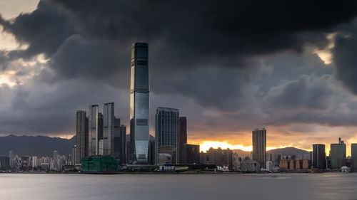 Modern buildings in city against sky during sunset