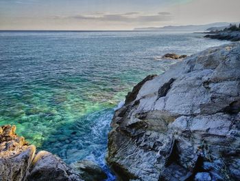 Scenic view of rocks in sea against sky