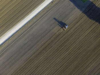 Aerial view of a tractor working in an agricultural field in udine, friuli venezia giulia, italy. 