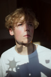 Close-up of young man looking away sitting at home